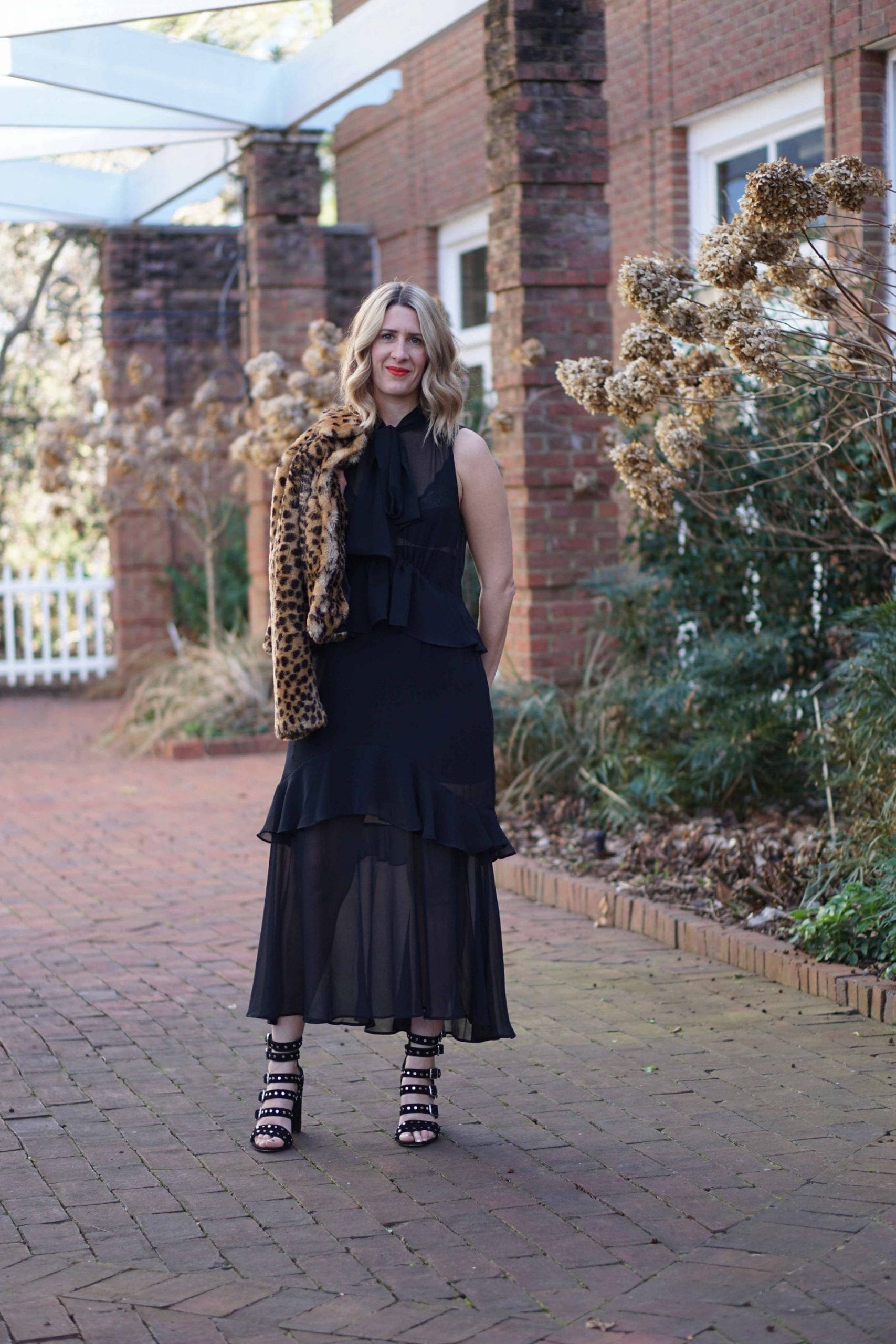 A black sheer dress worn for the evening with a leopard print coat