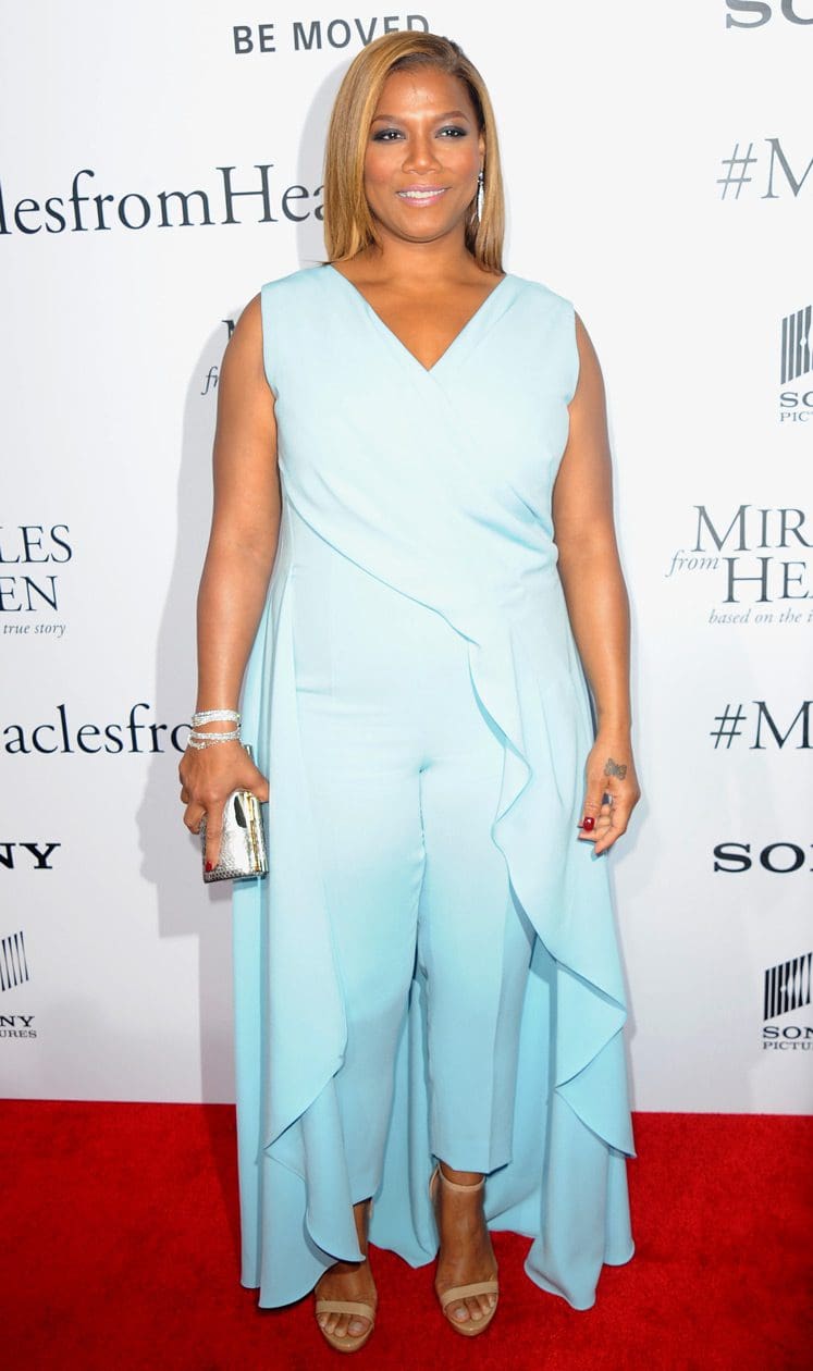 Queen Latifah wearing a pale blue jumpsuit with ruffles