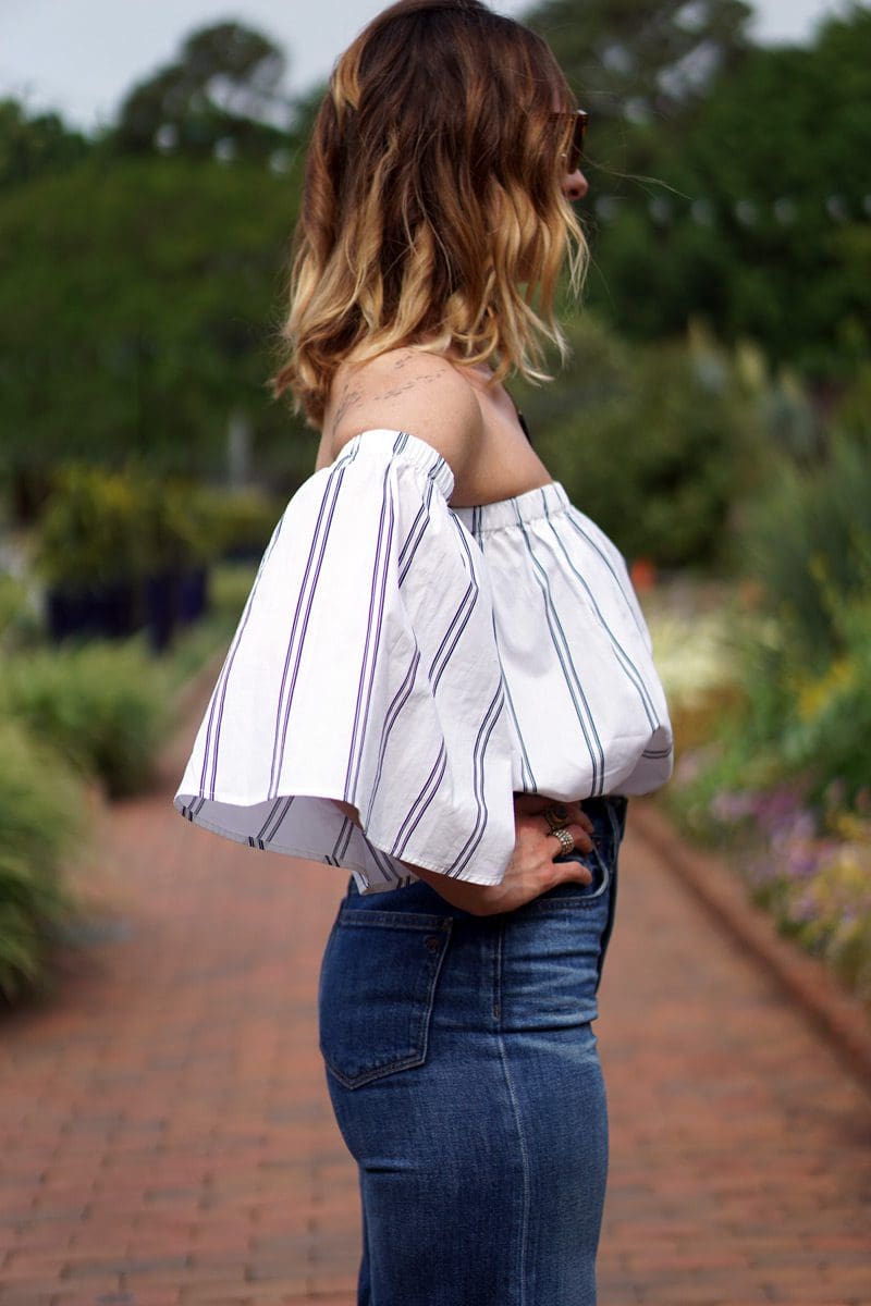An image of a pear shaped women wearing an off the shoulder top to balance her body shape