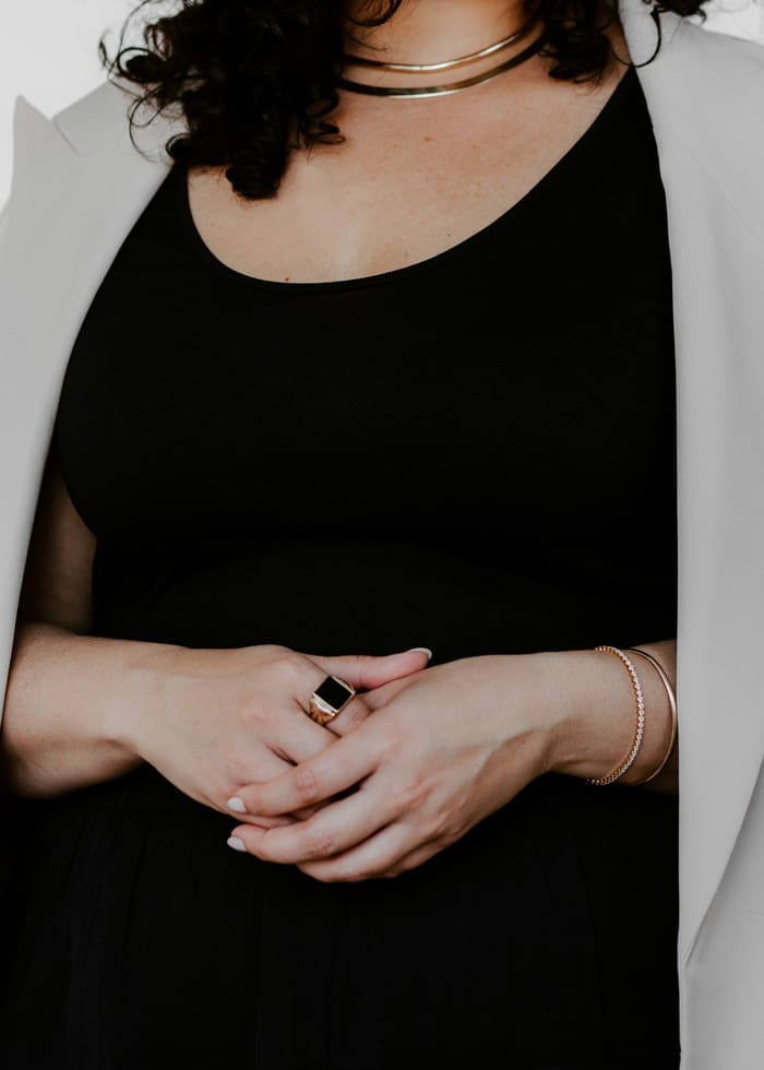 A photo of an hourglass shaped woman wearing a scoop neck top